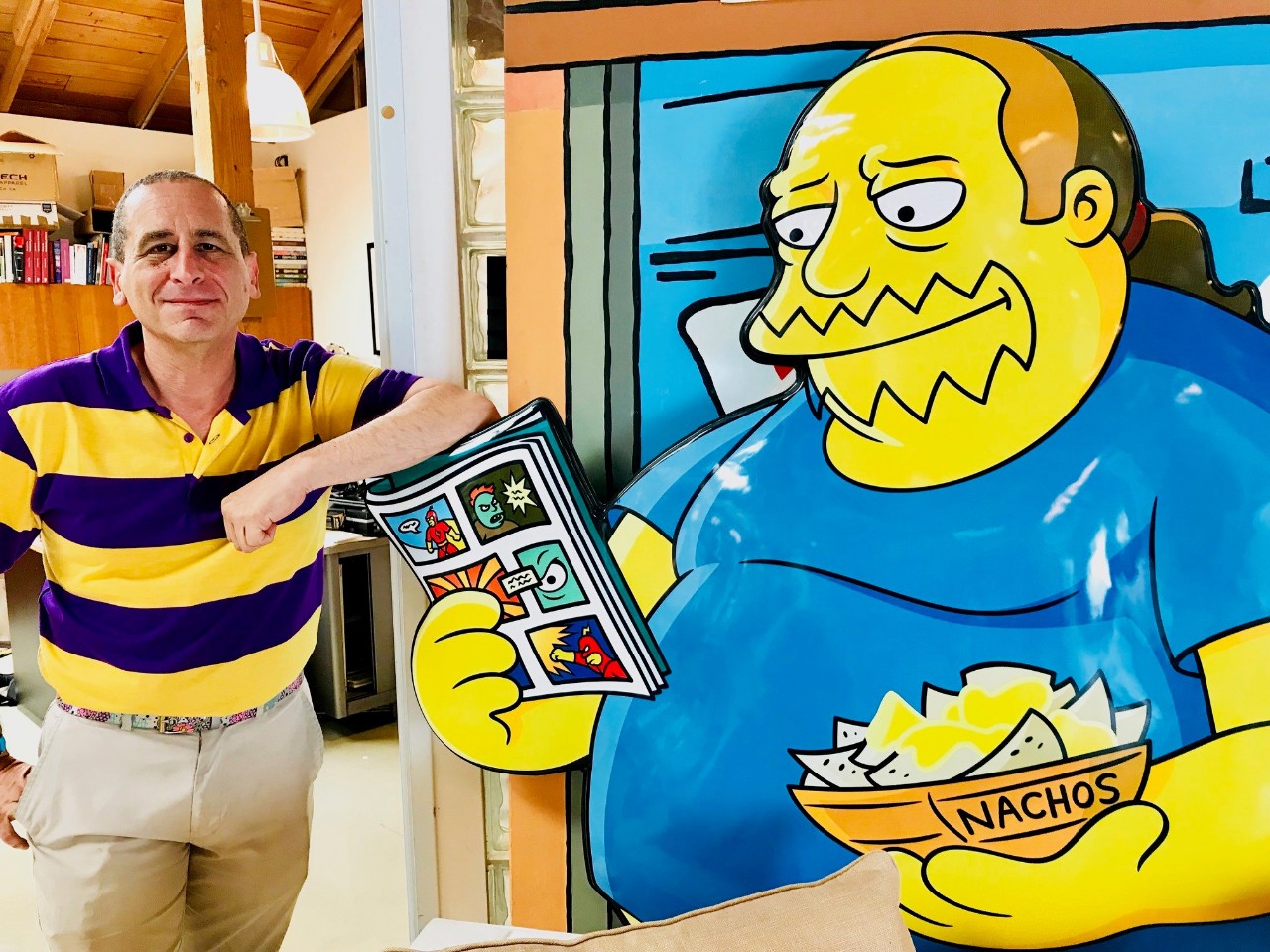 Mike Reiss, writer for The Simpsons, next to his cartoon drawing of the writer.